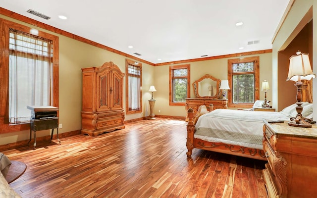 bedroom featuring ornamental molding and hardwood / wood-style floors