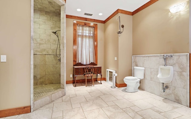 bathroom featuring crown molding, toilet, a tile shower, tile walls, and tile floors