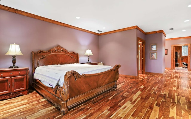 bedroom featuring wood-type flooring and ornamental molding