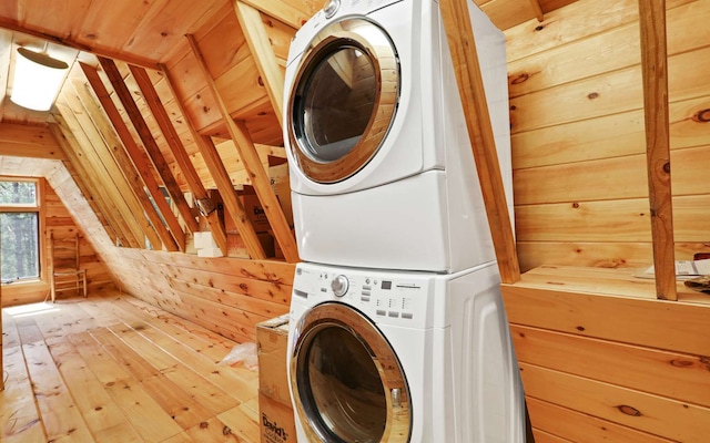 laundry area with stacked washer and dryer, wood walls, wood ceiling, and light hardwood / wood-style floors