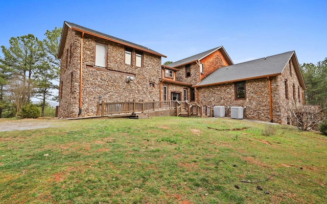 rear view of house with a lawn, a deck, and central AC