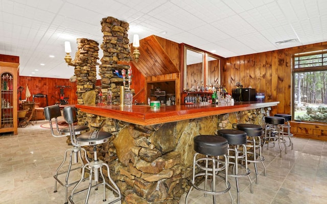 bar with wooden walls and light tile flooring