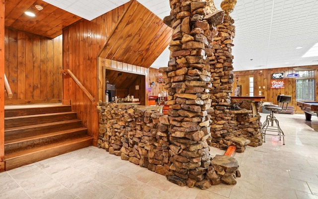 wine room with light tile flooring, bar area, wood walls, high vaulted ceiling, and pool table