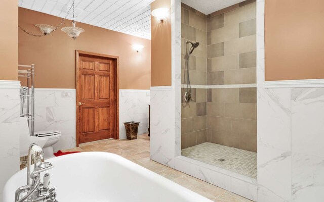 bathroom featuring tile walls, tile floors, toilet, and independent shower and bath