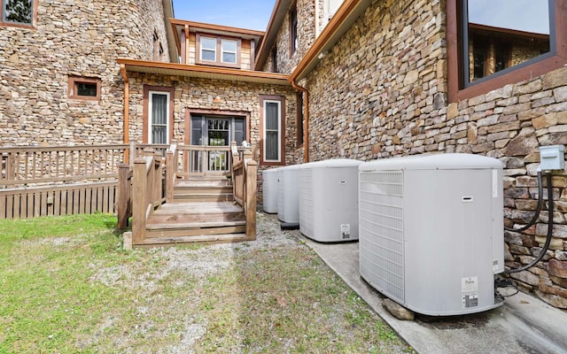 exterior space with central air condition unit and a yard