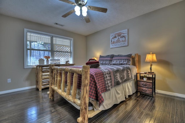 bedroom with ceiling fan, dark wood-type flooring, and a textured ceiling