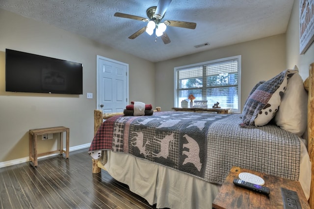 bedroom with a textured ceiling, ceiling fan, and dark wood-type flooring