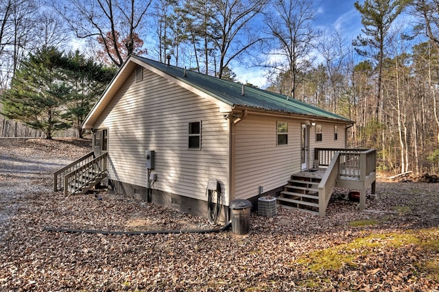 view of property exterior featuring central AC unit and a wooden deck