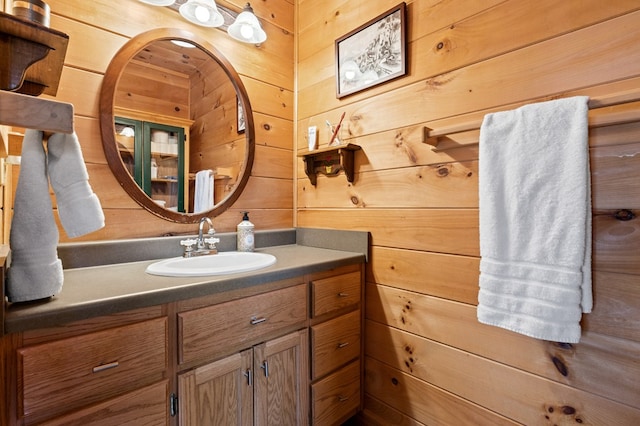 bathroom featuring vanity and wood walls