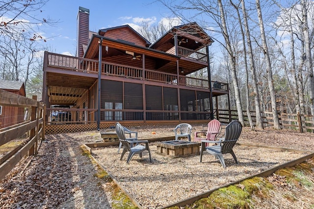 back of house featuring a fire pit, fence, a chimney, a deck, and log veneer siding