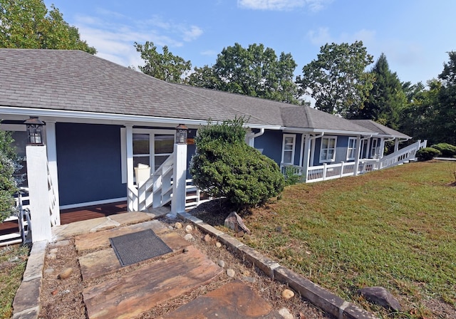 view of front of home featuring covered porch and a front lawn