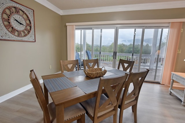 dining area featuring crown molding and light hardwood / wood-style flooring