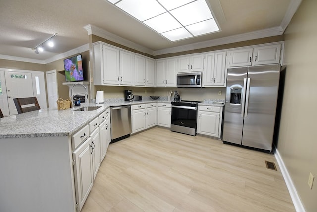 kitchen featuring white cabinetry, light stone countertops, kitchen peninsula, crown molding, and appliances with stainless steel finishes