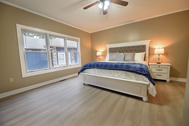 bedroom featuring a textured ceiling, ceiling fan, light hardwood / wood-style floors, and crown molding