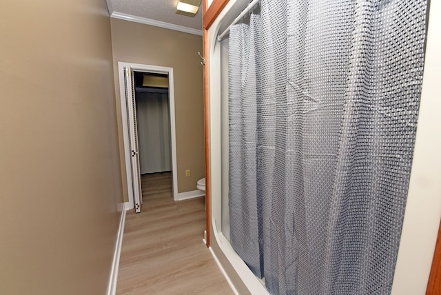 interior space featuring walk in shower, a textured ceiling, toilet, hardwood / wood-style flooring, and ornamental molding