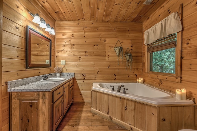 bathroom with wooden ceiling, a bath, wood walls, hardwood / wood-style floors, and vanity