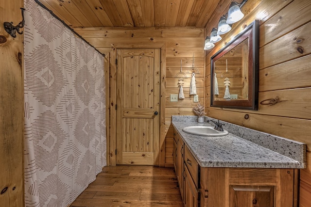 bathroom featuring hardwood / wood-style floors, vanity, wooden ceiling, and wood walls