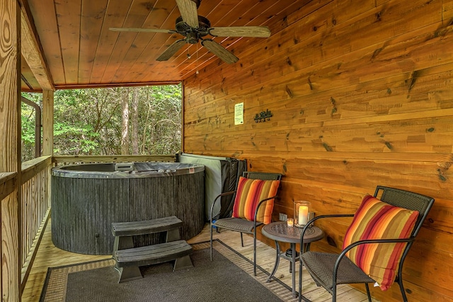 exterior space with wood ceiling, a jacuzzi, ceiling fan, hardwood / wood-style floors, and wood walls