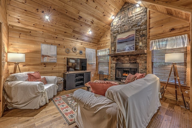 living room featuring high vaulted ceiling, wood walls, hardwood / wood-style floors, a fireplace, and wood ceiling