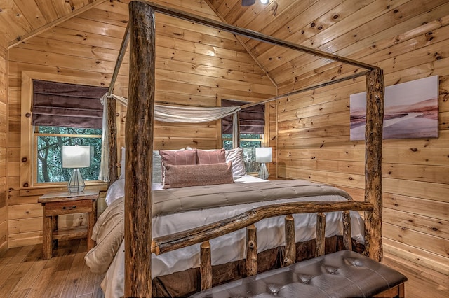 bedroom with wood-type flooring, wooden walls, lofted ceiling, and wood ceiling