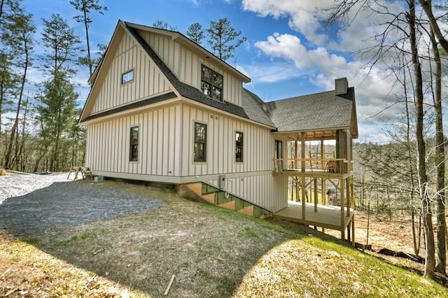 back of property featuring board and batten siding and roof with shingles