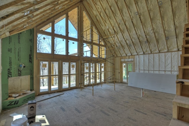 unfurnished living room featuring a healthy amount of sunlight and high vaulted ceiling