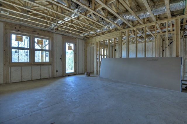 misc room featuring plenty of natural light and unfinished concrete floors