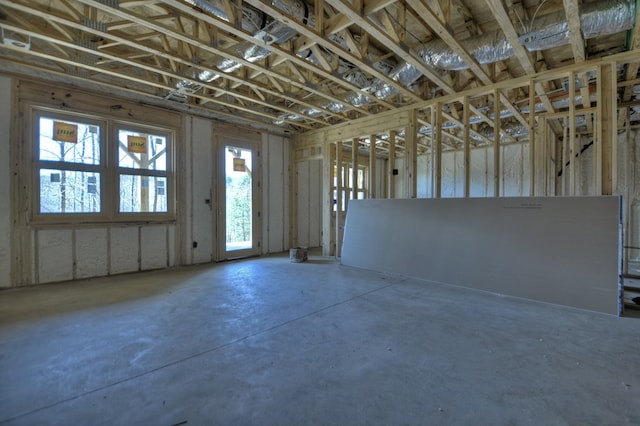 miscellaneous room with a healthy amount of sunlight and unfinished concrete floors