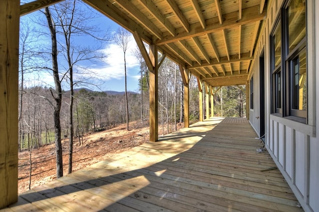 deck featuring a forest view and a mountain view