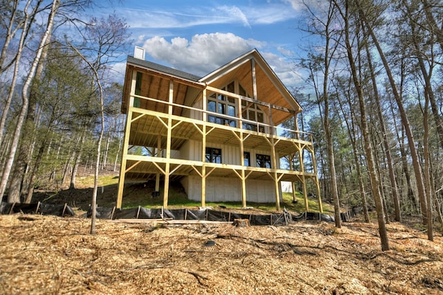 back of house with a wooden deck and board and batten siding