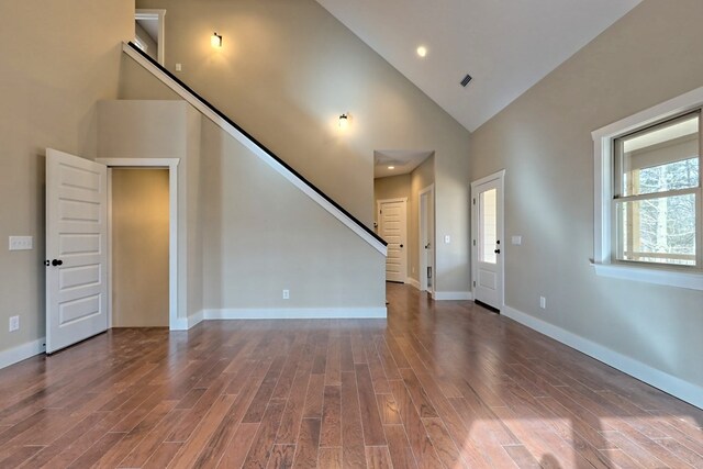 kitchen with white cabinets, dark hardwood / wood-style flooring, a chandelier, light stone countertops, and stainless steel fridge