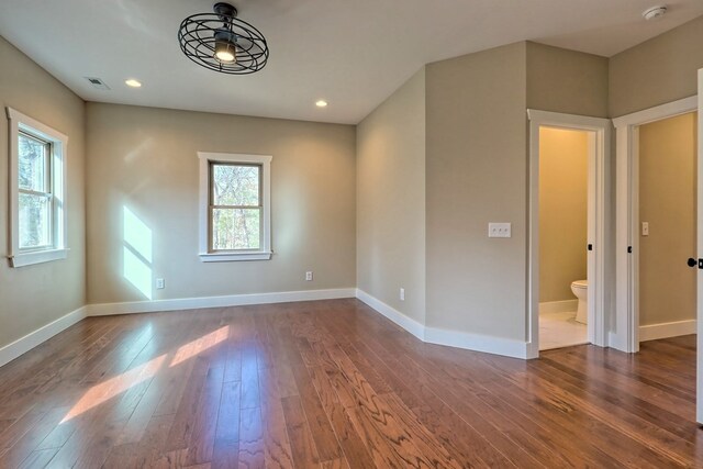 empty room featuring a wealth of natural light, ceiling fan, and wood-type flooring