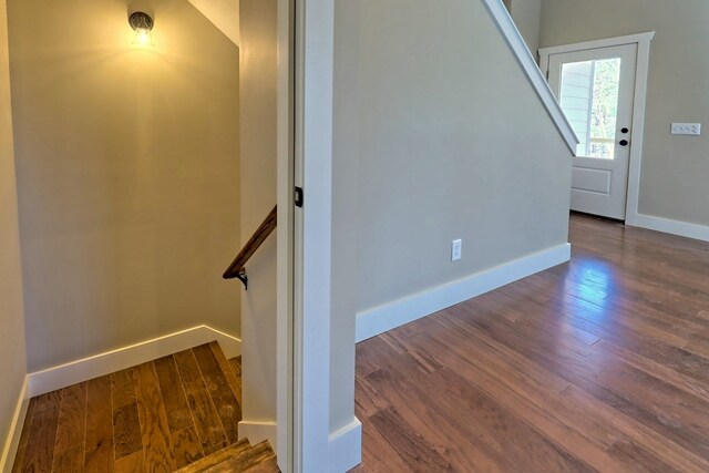 corridor with hardwood / wood-style flooring and vaulted ceiling