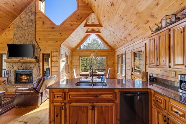 kitchen featuring a fireplace, wooden walls, sink, and light wood-type flooring