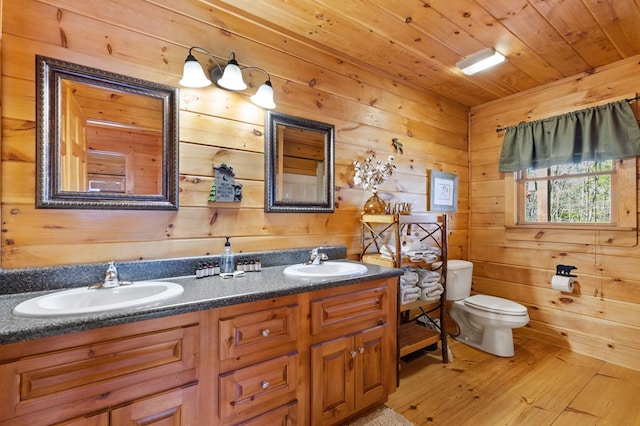 bathroom with toilet, wood walls, hardwood / wood-style flooring, wooden ceiling, and vanity