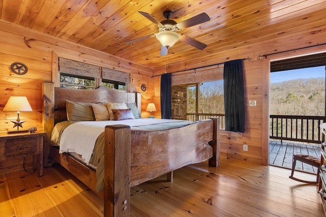 bedroom with wooden ceiling, ceiling fan, wooden walls, light wood-type flooring, and access to outside