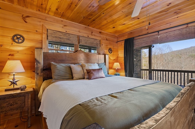 bedroom with wooden walls, multiple windows, hardwood / wood-style floors, and wooden ceiling