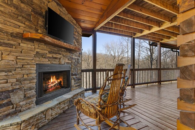 wooden deck with an outdoor stone fireplace