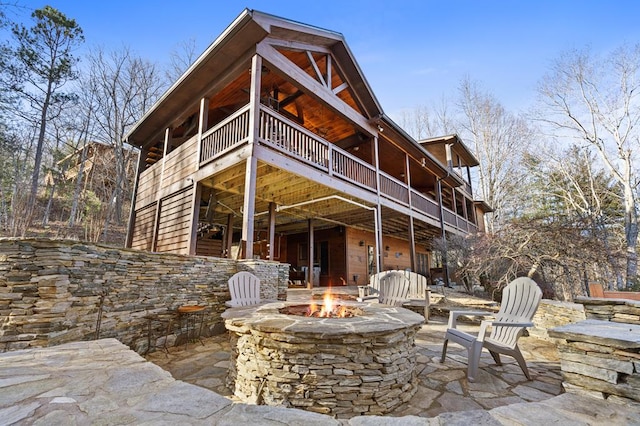 rear view of property with an outdoor fire pit and a patio