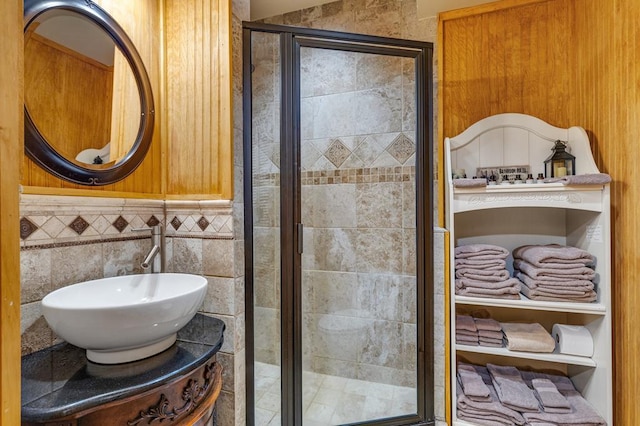 full bathroom featuring a stall shower, tile walls, and vanity