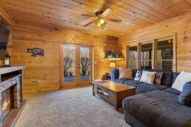 living room with a stone fireplace, french doors, plenty of natural light, and wood ceiling