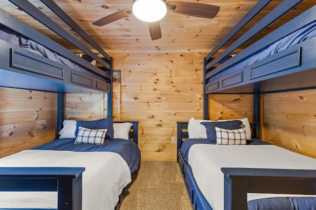 bedroom with wood ceiling, light colored carpet, wood walls, and ceiling fan