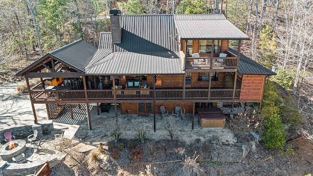 rear view of property featuring a wooden deck and a fire pit