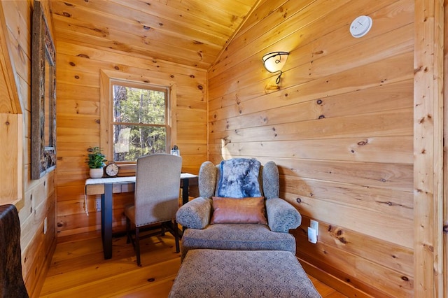 living area with wood ceiling, vaulted ceiling, wooden walls, and wood finished floors