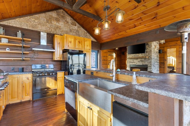 kitchen featuring wall chimney exhaust hood, hanging light fixtures, dark wood-type flooring, a sink, and black appliances