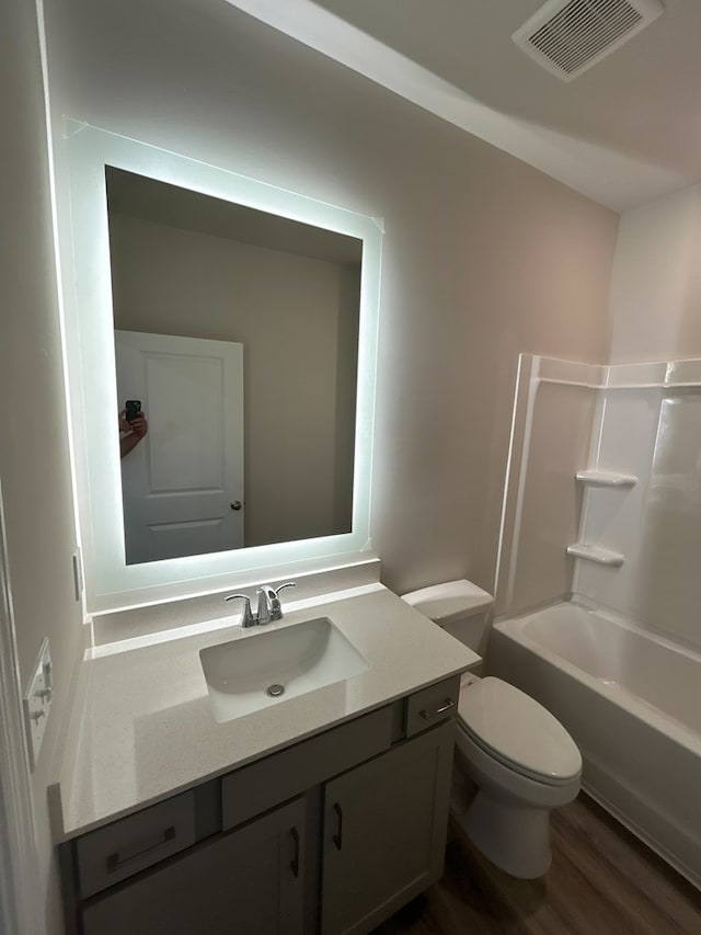 full bathroom featuring vanity, wood-type flooring, bathtub / shower combination, and toilet