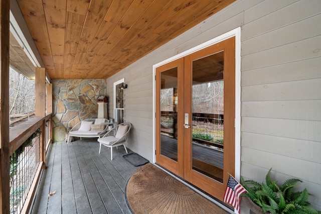 wooden deck with covered porch and french doors