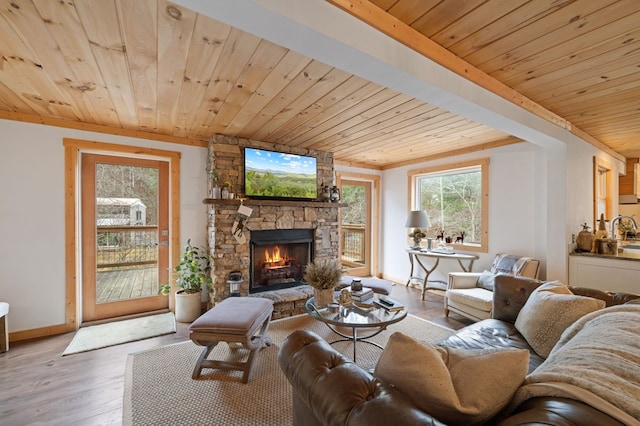 living room featuring wooden ceiling, hardwood / wood-style floors, and a stone fireplace