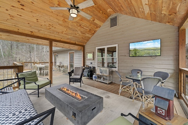 exterior space with ceiling fan, a wooden deck, and an outdoor living space with a fire pit