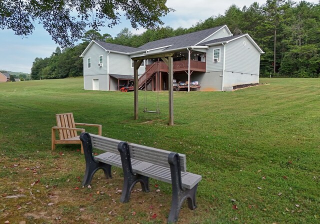 back of property with a garage, cooling unit, and a yard